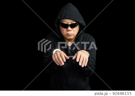 手錠を掛けられたサングラスの男 92696155
