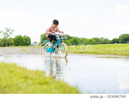 水溜りの道　自転車に乗る女の子 92696749