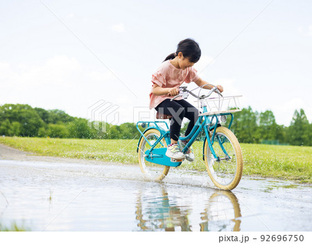 水溜りの道　自転車に乗る女の子 92696750