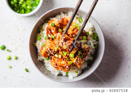 Korean dubu-jorim - braised spicy bean curd with rice in gray bowl, light background. Asian vegetarian food concept. 92697538