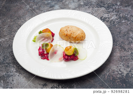 fish cutlet with vegetable side dish on a white plate in a restaurant 92698281