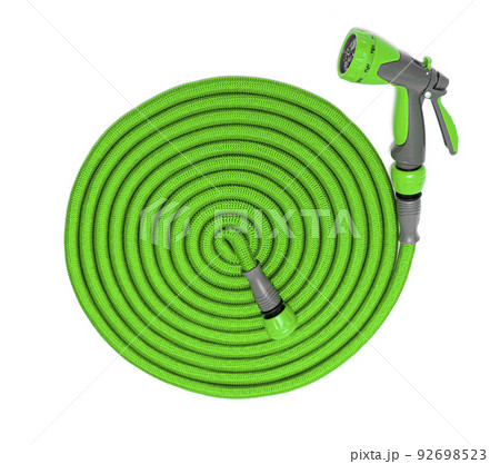 Water taps and a green garden hose with a sprayer 92698523