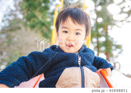 滑り台から楽しそうに滑り降りてくる子ども 92698851