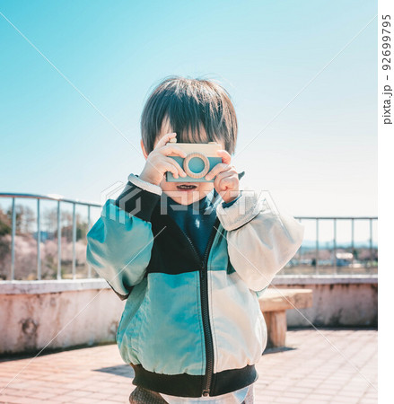 おもちゃのカメラを構える子ども 92699795