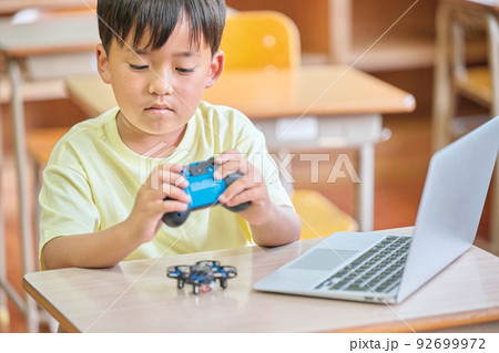 教室でドローンを操作する小学生の男の子 92699972