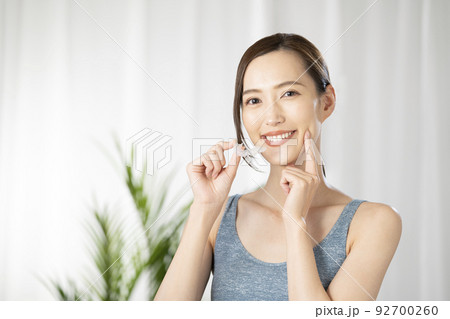 片手でマウスピースを持つ女性 92700260