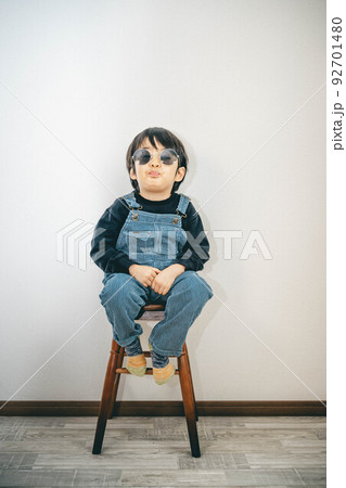 サングラスをかけて椅子に座っている子ども サングラスをかけて椅子に座っている子ども 92701480