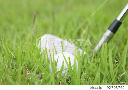 Golf ball and golf club on grass 92703762