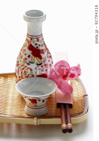 Sake flask and cups on bamboo Sake flask and cups on bamboo 92704316
