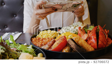 Woman take photo on her all day breakfast in coffee shop Woman take photo on her all day breakfast in coffee shop 92706072