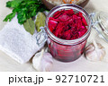 Healthy fermented canned cabbage sauerkraut with beetroot and herbs in a glass jar top view. 92710721