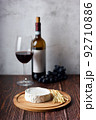 Still life of wine, cheese and grapes on wooden table. 92710886