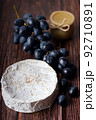 Wheel Camembert with black grapes and honey on wooden table. 92710891