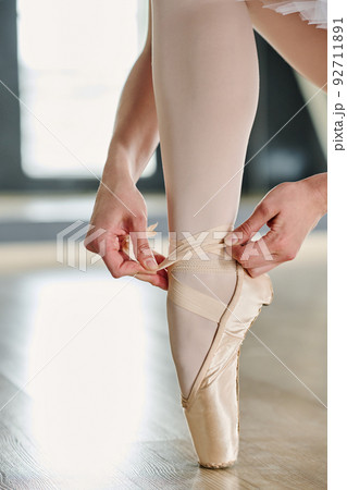 Close-up of lower part of leg of graceful ballet dancer in white tights 92711891