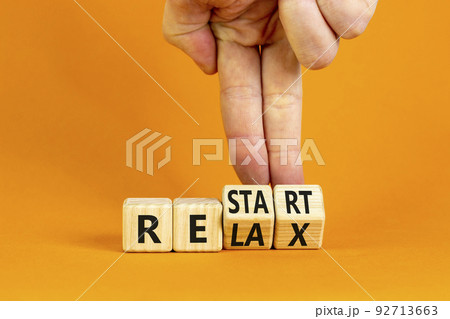 Relax and restart symbol. Businessman turns cubes and changes the word 'relax' to 'restart'. Beautiful orange table, orange background. Business, relax and restart concept. Copy space. Relax and restart symbol. Businessman turns cubes and changes the word 'relax' to 'restart'. Beautiful orange table, orange background. Business, relax and restart concept. Copy space. 92713663