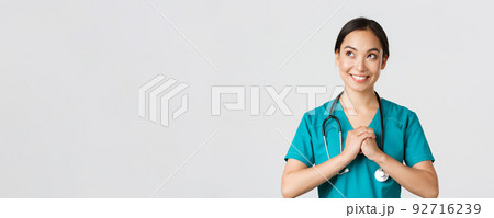 Healthcare workers, preventing virus, quarantine campaign concept. Determined and confident asian female physician in scrubs, clench hands together, getting ready, looking upper left corner Healthcare workers, preventing virus, quarantine campaign concept. Determined and confident asian female physician in scrubs, clench hands together, getting ready, looking upper left corner 92716239