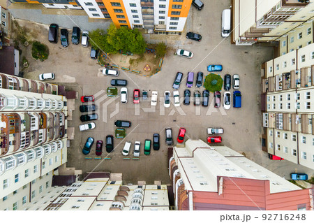 Aerial view of parked cars on parking lot between high apartment buildings. 92716248