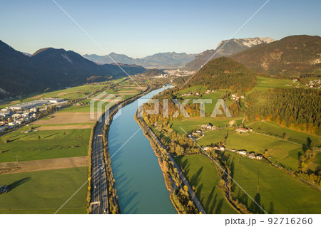 Aerial view of highway interstate road with fast moving traffic near big river in Alps mountains Aerial view of highway interstate road with fast moving traffic near big river in Alps mountains 92716260