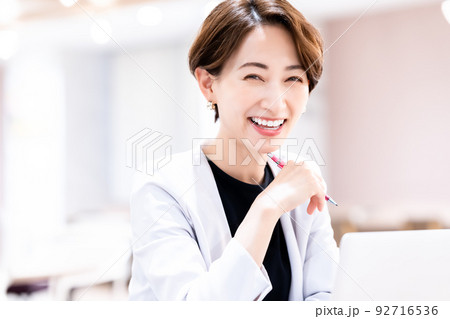 おしゃれなオフィスでノートパソコンを使うミドル女性 92716536