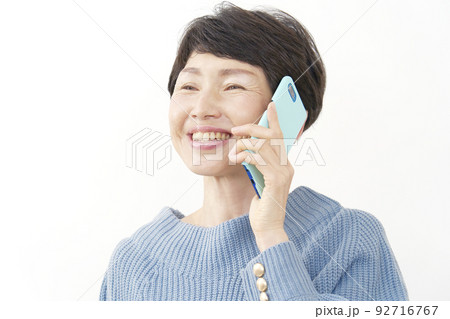 スマホで電話するシニア女性 白バック スマホで電話するシニア女性 白バック 92716767