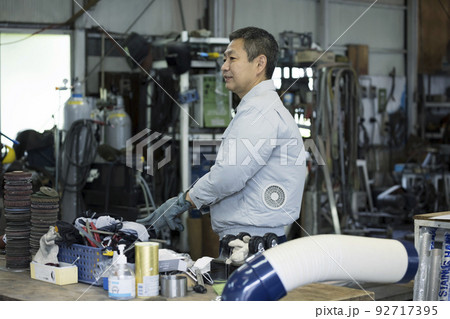 工場内で溶接手袋をして準備をする作業員男性　 92717395