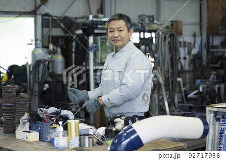 工場内で溶接手袋をして準備をする作業員男性 工場内で溶接手袋をして準備をする作業員男性 92717938