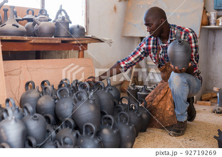 Potter checking quality of ceramic objects Potter checking quality of ceramic objects 92719269