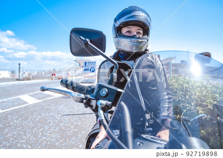 大型アメリカンバイクで横浜をツーリングする笑顔の女性ライダー 92719898