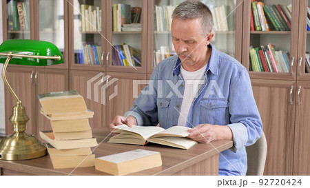 Portrait of caucasian Senior man working with book in public library. Adult student at the library 92720424