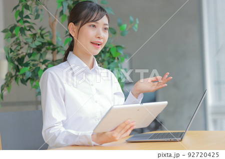 タブレットを持ちお客様の意向を聞くアドバイザー1 92720425