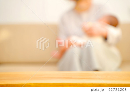 ソファーで赤ちゃんをあやす母親 テーブルの商品背景 ソファーで赤ちゃんをあやす母親 テーブルの商品背景 92721203