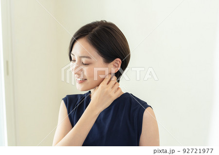 室内で首を気にする女性 92721977