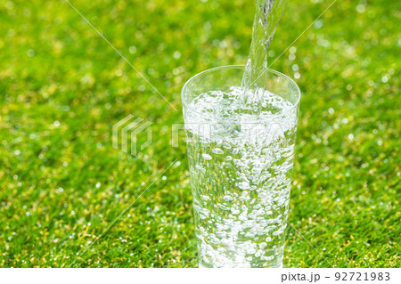芝生の公園でコップに水を注ぐ 芝生の公園でコップに水を注ぐ 92721983