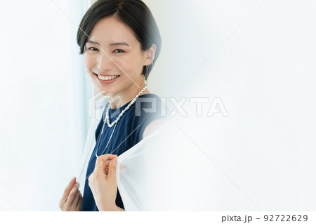 笑顔でシャツを羽織る女性 92722629