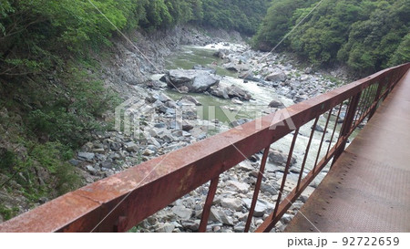 廃線跡の錆びれた橋を渡り見える川 92722659
