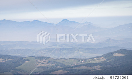 Autumn landscape with valley and big mountains disappearing in fog in the background, Europe Autumn landscape with valley and big mountains disappearing in fog in the background, Europe 92723061