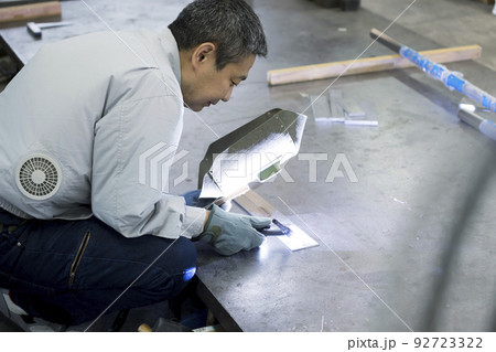 溶接工イメージ　空調作業服を着て溶接をするミドル男性作業員 92723322