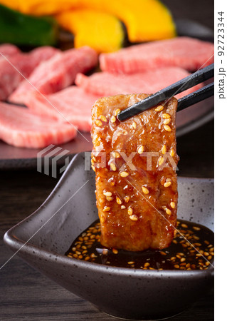 焼肉をタレをつけて食べる 焼肉をタレをつけて食べる 92723344
