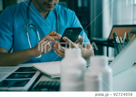 Pharmacists or doctors study information about tablets in the operating room in the evening. Pharmacists or doctors study information about tablets in the operating room in the evening. 92724056