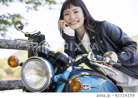 バイク女子イメージ　バイクのタンクに頬杖をつく若い女性 92724239