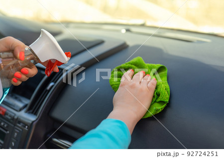 woman cleaning her car cockpit using spray and microfiber cloth. Cleaning the car, cleaning the interior of the car with a microfiber cloth woman cleaning her car cockpit using spray and microfiber cloth. Cleaning the car, cleaning the interior of the car with a microfiber cloth 92724251
