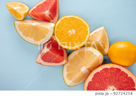 Fresh Citrus Fruit. citrus fruits composition and slice on blue background, copy space. top view. Flatlay pattern of citrus orange, lemon, lime and grapefruit slices background. 92724258