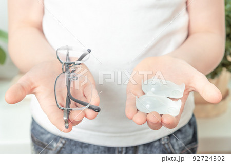 girl holding glasses and one day contact lens. myopia and eyesight problem concept girl holding glasses and one day contact lens. myopia and eyesight problem concept 92724302