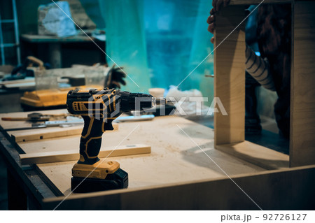 Electric screwdriver at workbench 92726127