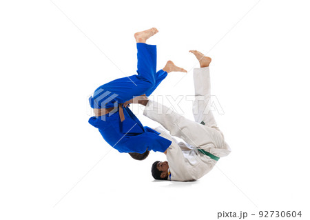 Studio shot of two men, professional judo athletes training isolated over white background Studio shot of two men, professional judo athletes training isolated over white background 92730604