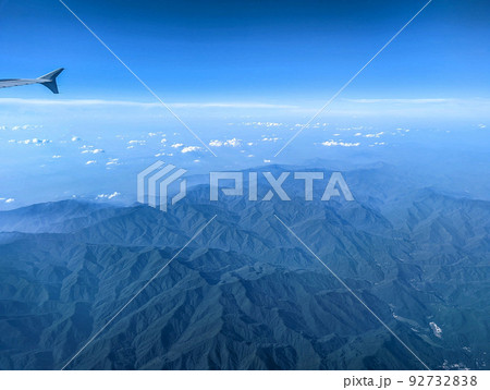Clouds and sky as seen through window of an aircraft Clouds and sky as seen through window of an aircraft 92732838