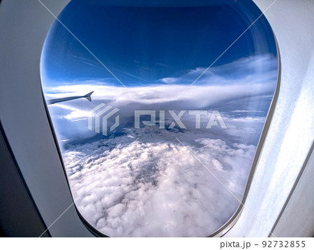 Clouds and sky as seen through window of an aircraft Clouds and sky as seen through window of an aircraft 92732855