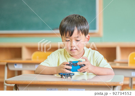 教室でドローンを操作する小学生の男の子 教室でドローンを操作する小学生の男の子 92734552