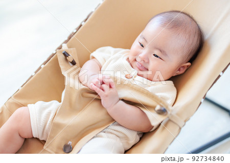 バウンサーに乗る笑顔の赤ちゃん バウンサーに乗る笑顔の赤ちゃん 92734840