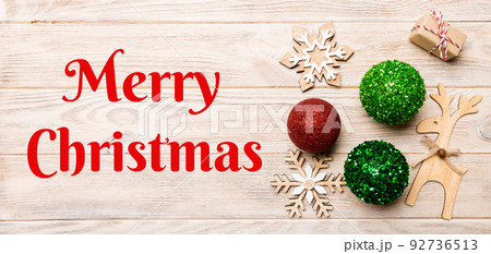 Merry Christmas text. New Year composition made of baubles, reindeer and other decorations on wooden background. Christmas time concept with empty space for your design 92736513